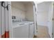 Efficient laundry room with modern washer and dryer units and a convenient storage shelf at 50989 Highway 27 # 371, Davenport, FL 33897