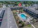 Aerial view of a condo complex featuring a sparkling blue pool and lush landscaping at 5505 Hernandes Dr # 204, Orlando, FL 32808