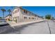 View of cream-colored condo with red shutters, decorative cinder block fence, and ample parking at 5505 Hernandes Dr # 204, Orlando, FL 32808