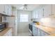 Functional kitchen with white cabinets, appliances, and a window providing natural light at 5505 Hernandes Dr # 204, Orlando, FL 32808