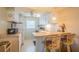 Compact kitchen featuring white cabinetry, a breakfast bar, and essential appliances at 5505 Hernandes Dr # 204, Orlando, FL 32808