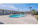 Inviting community pool surrounded by brick pavers, sun loungers, and manicured greenery at 5505 Hernandes Dr # 204, Orlando, FL 32808
