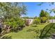 Lush backyard showcasing a lawn, beautiful trees, and manicured landscaping at 618 Crownclover Ave, Orlando, FL 32828