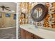Powder room with countertop vanity, framed mirror, and colorful wallpaper design at 618 Crownclover Ave, Orlando, FL 32828