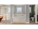 Bathroom showcasing a large soaking tub, tiled surround, separate shower, and frosted window at 618 Crownclover Ave, Orlando, FL 32828