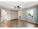 Spacious bedroom featuring wood floors, a fan, and bright natural light from the large window at 618 Crownclover Ave, Orlando, FL 32828