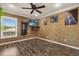 Bedroom featuring wood-look flooring, a ceiling fan, and a wall-mounted television at 618 Crownclover Ave, Orlando, FL 32828