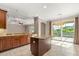 Open kitchen featuring granite countertops, center island, tile floors, and backyard views at 618 Crownclover Ave, Orlando, FL 32828