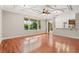 Open living area with hardwood floors, large windows, and a decorative ceiling fan at 618 Crownclover Ave, Orlando, FL 32828