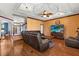 Open-concept living room with rich hardwood flooring, a large sectional, and stairs in background at 618 Crownclover Ave, Orlando, FL 32828