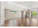 Open-concept living room with wood floors, tray ceiling, custom lighting design and large windows at 618 Crownclover Ave, Orlando, FL 32828