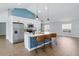 Modern kitchen features white cabinets, stainless steel appliances, an island with bar seating, and wood-look floors at 751 Via Milano, Apopka, FL 32712