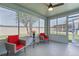 Enclosed sunroom with ceiling fan, red accent pillows, and lots of natural light at 751 Via Milano, Apopka, FL 32712