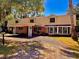 Two-story home with a carport and brick accents, complemented by a well-maintained gravel driveway and verdant surroundings at 76 Oakdale St, Windermere, FL 34786