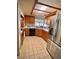 Charming kitchen featuring light wood cabinetry, stainless steel appliances, tile flooring, and a bright window view at 76 Oakdale St, Windermere, FL 34786
