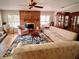 Cozy living room with a brick fireplace, wood floors, large patterned rug, and inviting seating arrangement at 76 Oakdale St, Windermere, FL 34786