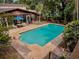 Aerial view of a private pool surrounded by lush landscaping, offering a serene backyard retreat at 76 Oakdale St, Windermere, FL 34786