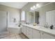 A well-lit bathroom features a shower, a tub, and double sinks with a large mirror at 9915 Kona Isle Ct, Orlando, FL 32817