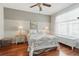 A bright bedroom with hardwood floors, a ceiling fan, and a large window with natural light at 9915 Kona Isle Ct, Orlando, FL 32817