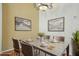 An elegantly furnished dining room features a granite table, chandelier, and decorative artwork at 9915 Kona Isle Ct, Orlando, FL 32817