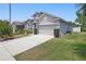 Well-maintained two-car garage home with a long driveway, verdant grass, and mature plantings at 9915 Kona Isle Ct, Orlando, FL 32817