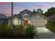 Charming single-Gathering home featuring a well-maintained lawn, flowering plants, and a red front door at 9915 Kona Isle Ct, Orlando, FL 32817