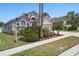 Charming single Gathering home with mature landscaping, large arched windows, and an attached two-car garage at 9915 Kona Isle Ct, Orlando, FL 32817