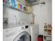 Laundry room with washer, dryer, and storage shelves at 9915 Kona Isle Ct, Orlando, FL 32817