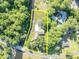 This aerial view shows the home and property with pool surrounded by mature trees at 1003 Shore Dr, Kissimmee, FL 34744