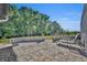 Enjoy outdoor relaxation on this back patio featuring lovely brickwork, beautiful planters, and comfortable lounge seating at 1003 Shore Dr, Kissimmee, FL 34744