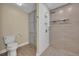 Modern bathroom featuring a stand-up shower, gray tile, and storage cabinet at 1003 Shore Dr, Kissimmee, FL 34744
