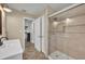 Bathroom featuring a glass-enclosed shower and a white single sink vanity with herringbone tile flooring at 1003 Shore Dr, Kissimmee, FL 34744