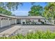 Charming single-story home with a two-car garage, double-door entrance, white brick and mature landscaping at 1003 Shore Dr, Kissimmee, FL 34744