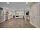 Open-concept kitchen featuring modern appliances, white cabinetry, stone backsplash, and herringbone wood flooring at 1003 Shore Dr, Kissimmee, FL 34744