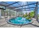 This screened-in pool features lush landscaping, elegant stonework, and stylish lighting at 1003 Shore Dr, Kissimmee, FL 34744