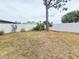 Large backyard enclosed by a white fence featuring a mature tree at 10235 Summer Elm Ave, Clermont, FL 34711