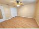 Bedroom features wood-look floors, ceiling fan, and a closet with white doors at 10235 Summer Elm Ave, Clermont, FL 34711
