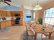 Staged dining room and kitchen feature wood cabinets, stainless appliances, and a cozy dining area for Gathering meals at 10235 Summer Elm Ave, Clermont, FL 34711