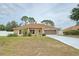 Charming single-story home featuring a well-maintained lawn and a two-car garage at 10235 Summer Elm Ave, Clermont, FL 34711