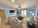 Stylishly staged living room features modern furniture, light blue walls, and sliding glass doors for seamless indoor-outdoor living at 10235 Summer Elm Ave, Clermont, FL 34711