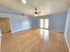 Spacious living room with light blue walls and wood flooring offers a blank canvas for creating a comfortable living space at 10235 Summer Elm Ave, Clermont, FL 34711