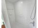 Walk-in shower featuring white tile, grab bars, and an adjustable shower head at 10235 Summer Elm Ave, Clermont, FL 34711