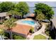Overhead view of the community pool, surrounded by mature trees and beautiful landscaping near the lake at 1156 Calle Del Norte # C, Casselberry, FL 32707