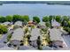 Aerial view of condo community with pool, clubhouse, parking, and lake in the background at 1156 Calle Del Norte # C, Casselberry, FL 32707