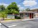 Community entrance with guard house, sign, lush landscaping, and street view at 1156 Calle Del Norte # C, Casselberry, FL 32707