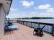 Spacious wood deck with peaceful lake views, lounge chairs, and black deck chairs at 1156 Calle Del Norte # C, Casselberry, FL 32707