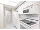Compact kitchen with white appliances, white cabinets, and tile flooring at 1156 Calle Del Norte # C, Casselberry, FL 32707