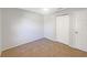 A bright bedroom features neutral walls, tan carpet and a closet at 12610 Bay Hill Dr, Grand Island, FL 32735