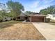 Charming single-story home with a well-maintained lawn, mature trees, and a two-car garage at 12610 Bay Hill Dr, Grand Island, FL 32735