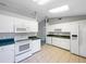 Functional kitchen with white cabinets, a microwave, a range, and a refrigerator at 12610 Bay Hill Dr, Grand Island, FL 32735